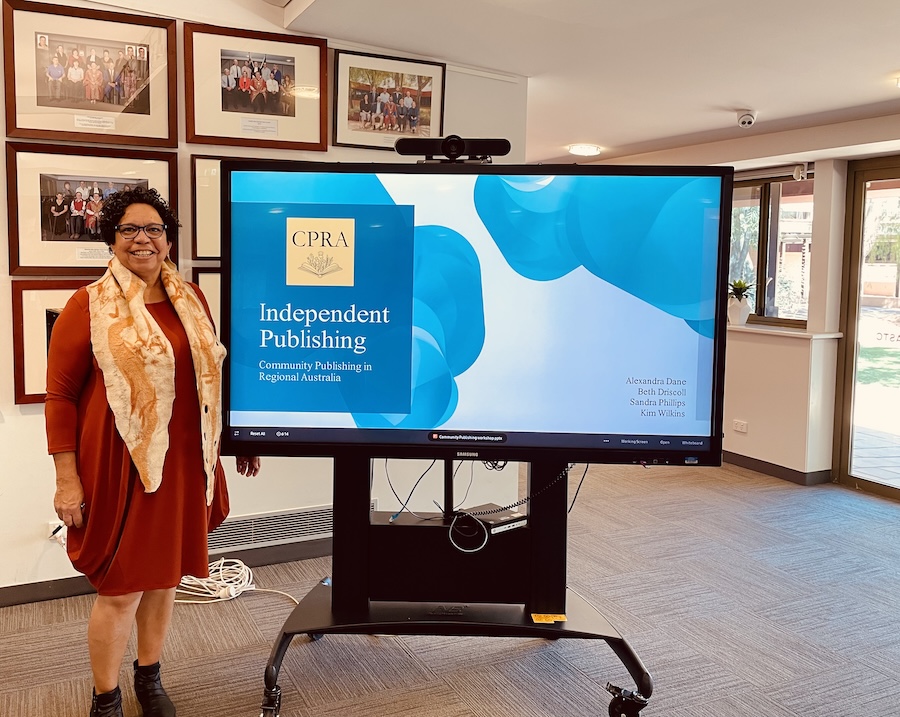 Smiling woman standing next to the presentation screen.