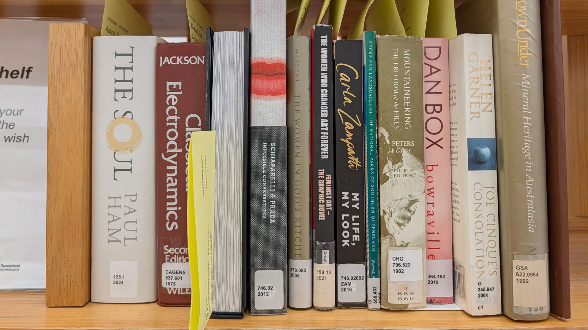 Close-up of reserved books lined up in a public library