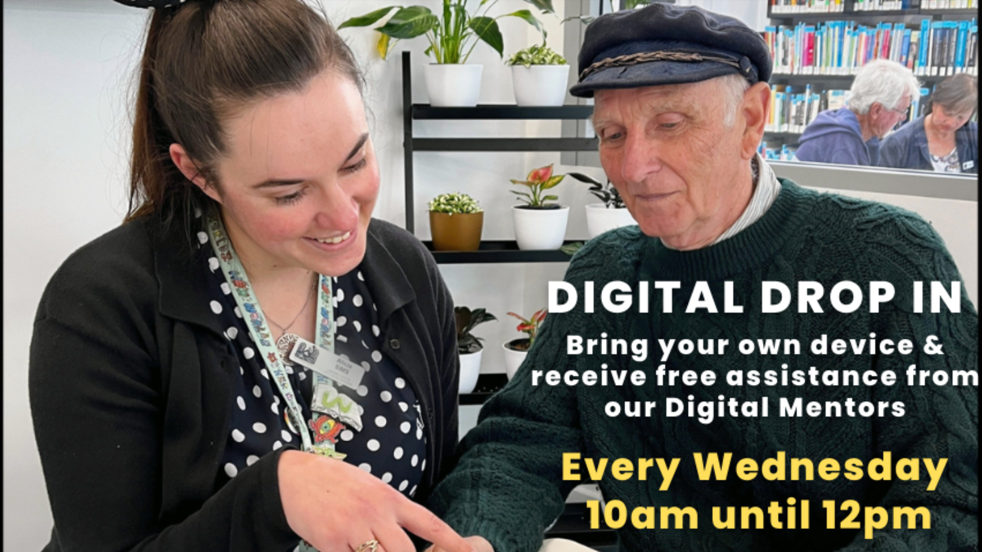 Untitled design (9) A library staff member sits beside an older patron, helping him use a digital device during a technology support session. Overlaid text promotes a weekly “Digital Drop In” program offering free assistance from Digital Mentors every Wednesday from 10am to 12pm.